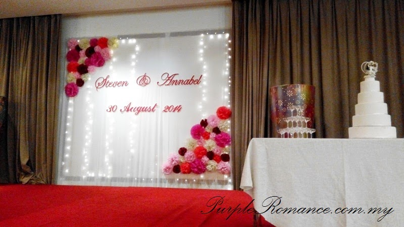 stage backdrop decoration, tissue flower, pom pom, personalised, bespoke, modern, colourful, hotel holiday inn glenmarie ballroom subang, KL, steven & annabel, wedding, welcome board, package, photo booth, instant print, bird cage, black and red, aisle, VIP centerpiece table decor, reception table, registration table decoration, bride and groom, red carpet, lamp, romantic, beige, ivory, maroon, pink, purple, red, Kuala Lumpur, Selangor