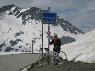 pep and bicycle at the summit of the Furkapass, alongside snow banks, Switzerland