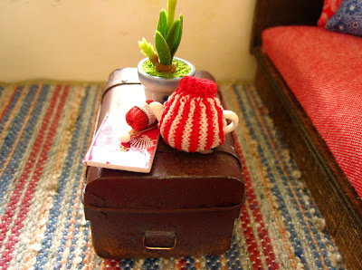 Modern dolls' house miniature stripy blue, fawn and red rug with trunk coffee table on top.