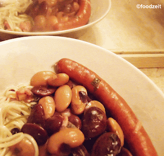 Serving portion of thick bean stew with Vienna sausages and noodles