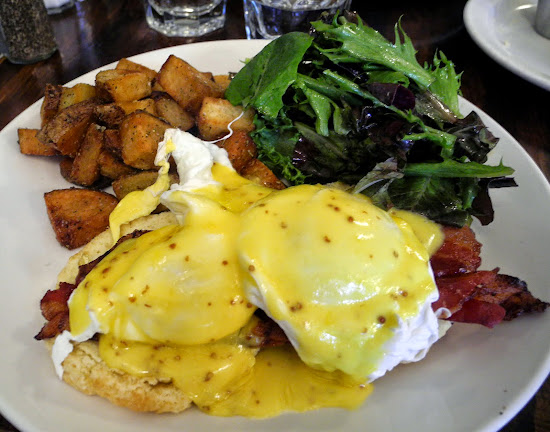 Eggs Benedict.Poached eggs, herbed biscuit w/ spiced bacon & Hollandaise.