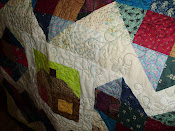 Close up of quilting on the scrappy heart quilt