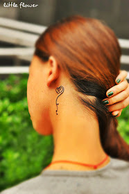 A concise little rose tattoo behind the ear.