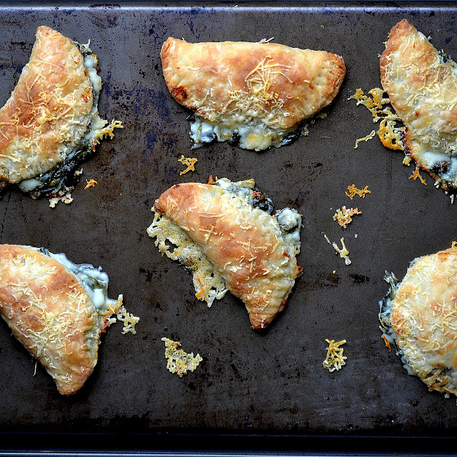 spinach artichoke hand pies on a pan
