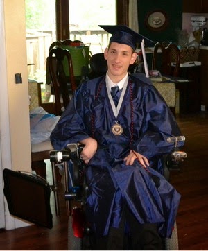 Bookshare member Zach Bryant, wearing college graduation cap and gown, seen sitting in a wheelchair.