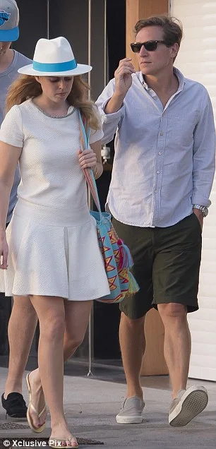 The royal, pictured with Mr Clark, added a splash of colour to her outfit with a vibrant bucket bag