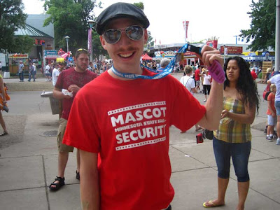 Young man in red tshirt with white letters reading Mascot Security Team