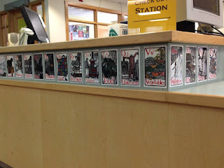 circulation desk with pages from an alphabet book around it