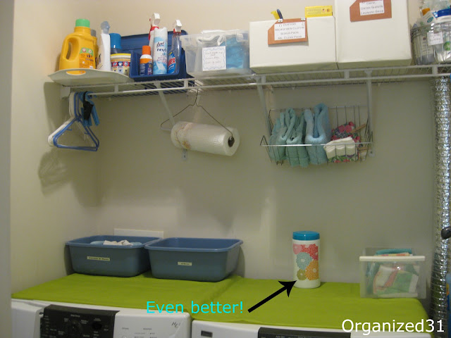 an organized laundry room with text reading Even Better! next to an arrow pointing to a repurposed wipes container