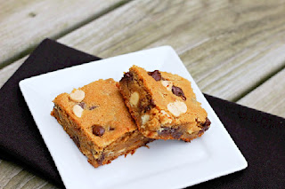 2 peanut butter chocolate chip blondies on a white plate with black napkin