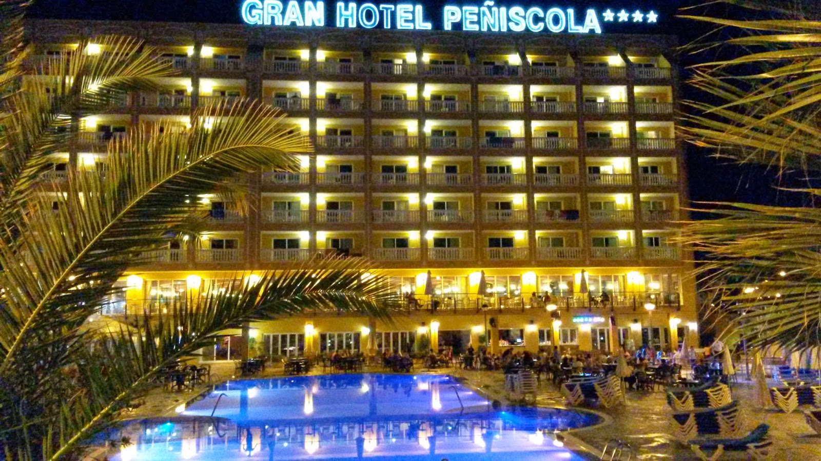 Vista nocturna de la entrada del hotel y su piscina