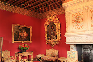 Una habitación con varios muebles viejos y paredes rojas 