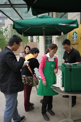several Chinese people being offered sample drinks