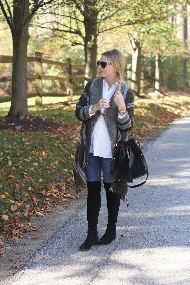 ray ban sunglasses, wool poncho, black over the knee boots, black bucket bag