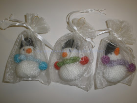 Muñequitos de nieve hechos a crochet para el árbol de Navidad envueltos en bolsitas de organza