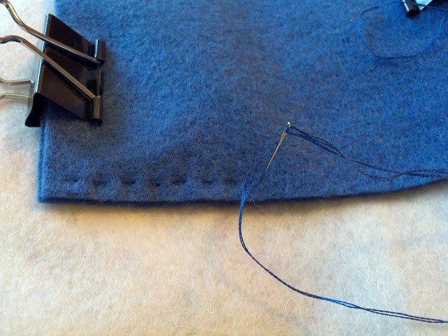 Binder clips hold the felt together while I work a running stitch along the sides
