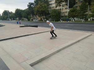 A youth roller-skating outside Kosmonavtlar Metro station on the square with statues of Cosmonauts.