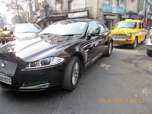 A "Jaguar" car caught in traffic jam with a "Ambassador Taxi".