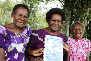 Biomabu Womens Groups  secretary and Village Birth Attendent Elisa Taipi (left), chairperson Gina Baidam (middle) and treasure Goigo Mapo displaying their Funding Deed.