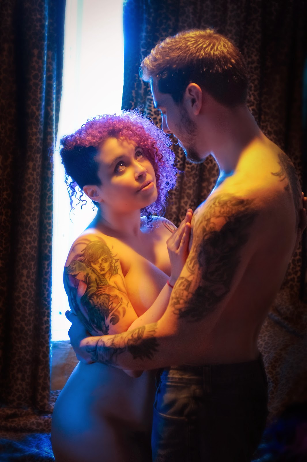 photo d'Envyus Deviant nue dans les bras d'un homme tatoué torse nu