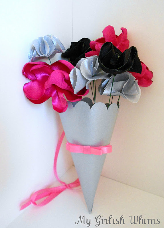 Silk satin flowers I made in a paper cone to be hung off of the pews with