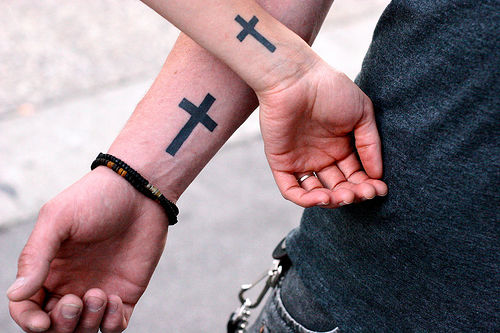 Small cross tattoo on hand