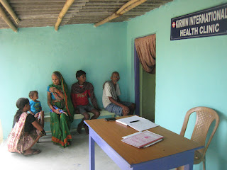 Four people and a child waitinf outside the Kirwin International Health Clinic to be seen. 
