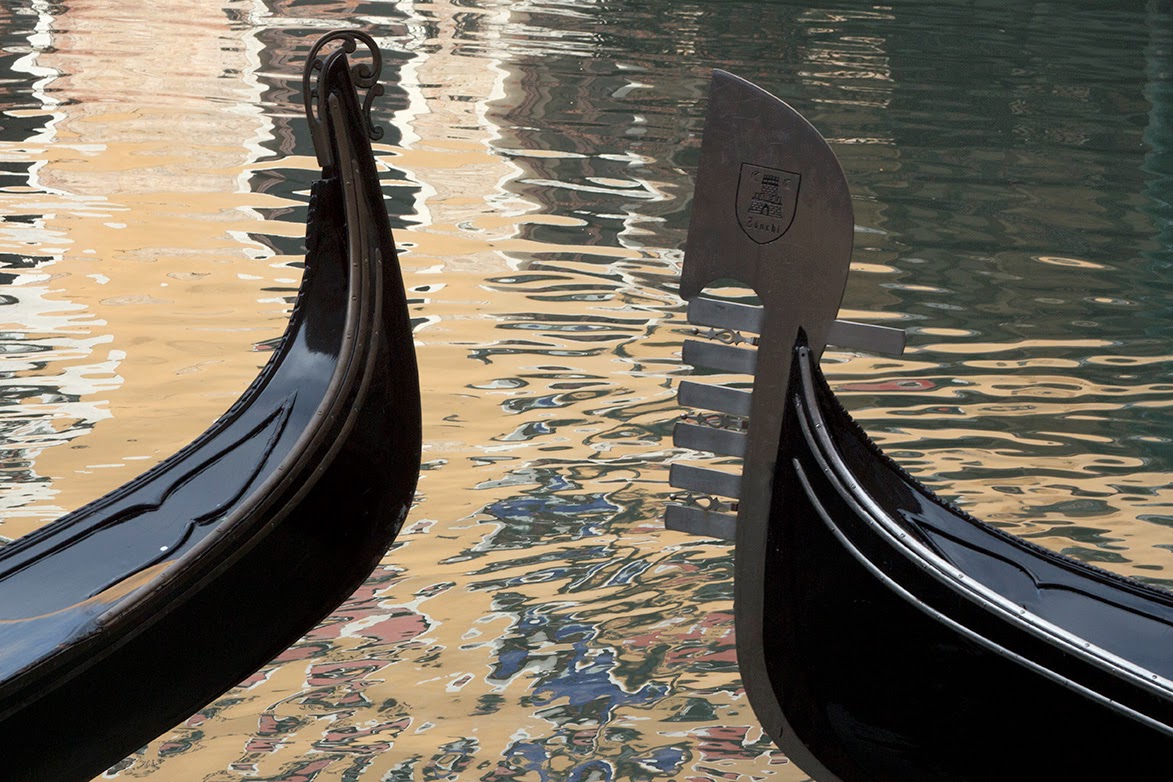 two gondelas and a reflection of a yellow palazzo in Venice