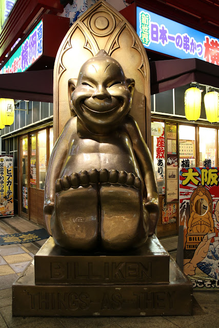 Biliken is a deity statue to bring good luck if you rub the soles of his feet at Tsutenkaku Tower in Osaka Shinsekai in Japan Biliken is a deity statue to bring good luck if you rub the soles of his feet at Tsutenkaku Tower in Osaka Shinsekai in Japan