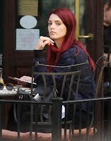 Ashley Greene with red hair sitting at a New York restaurant