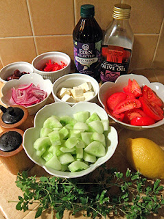 Bowls and Bottles of Greek Salad Ingredients with Pile of Fresh Oregano in Front