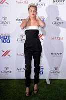 Miley Cyrus strikes a hot pose on the green carpet