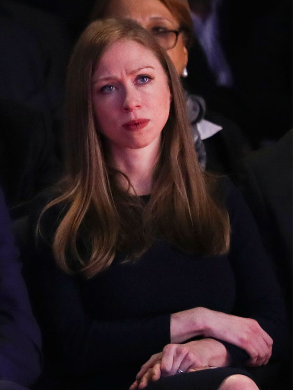 Chelsea Clinton holding her father's hand.