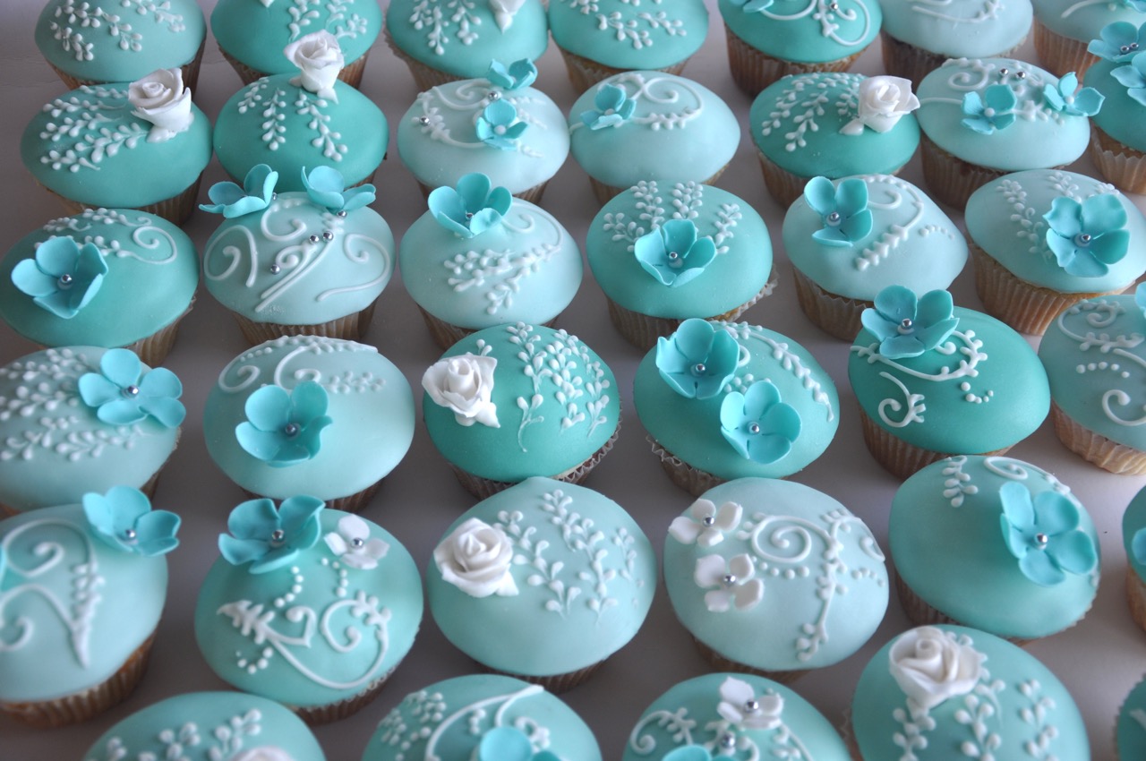 Turquoise cupcakes with flowers and lace pattern