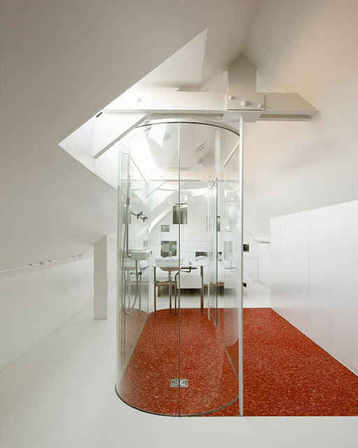 Habitación minimalista con baño de paredes de cristal