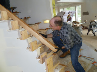 Shawn Christman of Seattle Stair & Design lifts a handrail up the stairs in Juneau, Alaska