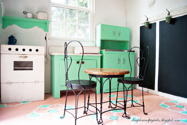 Playhouse with mint green cabinets, coral painted floor, chalkboard wainscoting and vintage accessories.