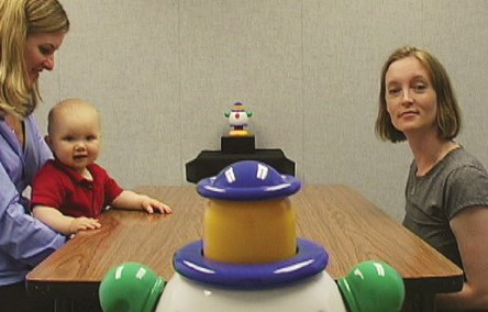 Una mamma, il figlio e un'altra donna seduti a un tavolo insieme a un robot
