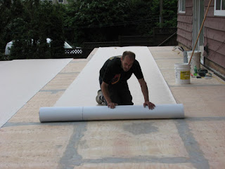 Duradek installer rolling out a sheet of PVC membrane