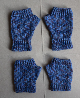 Two pairs of fingerless mitts made with variegated blue sock yarn. They have ribbing at the wrist and the base of the fingers. The top pair have a longer wristband and palm.