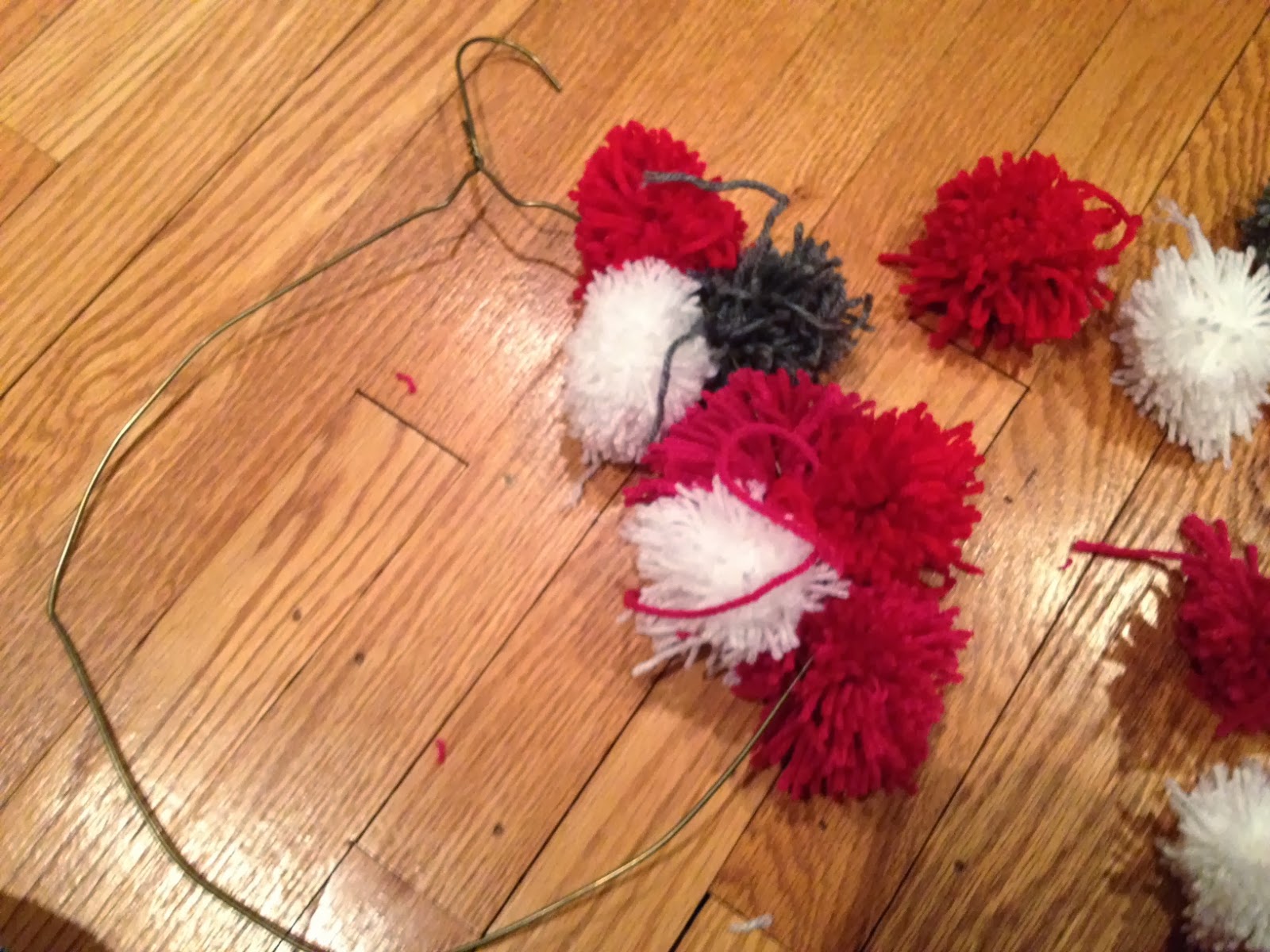Two It Yourself DIY Pom Pom Yarn Wreath on a Wire Hanger