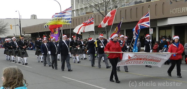 The Pipe Band plays in the parade being led by those carrying flags.