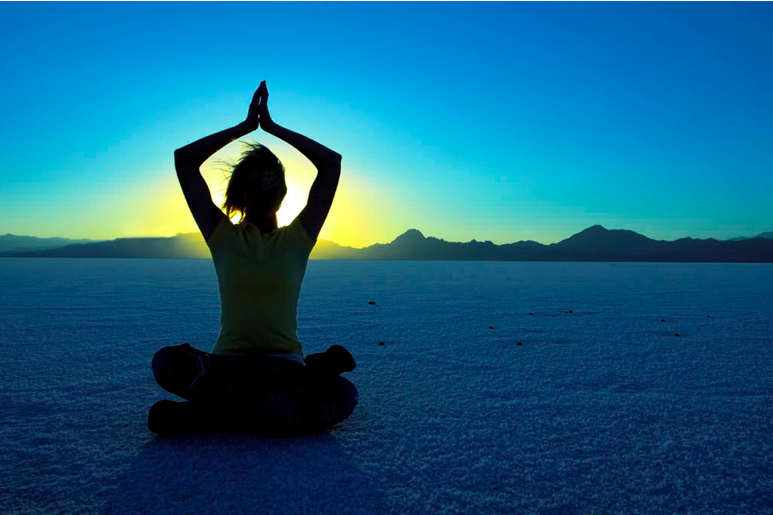 woman in yoga position outside at sunset