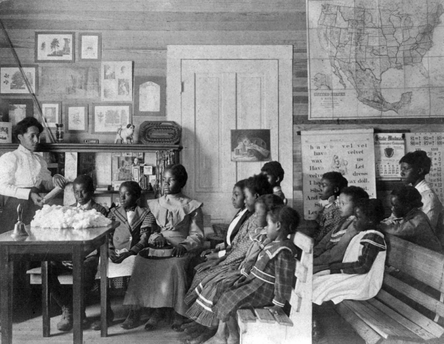 Frances+Benjamin+Johnston+-+African+American+children+and+teacher+in+classroom+studying+corn+and+cotton,+Annie+Davis+School,+near+Tuskegee,+Alabama,+1902.jpg
