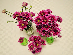 purple flowers arranged in multiple vases