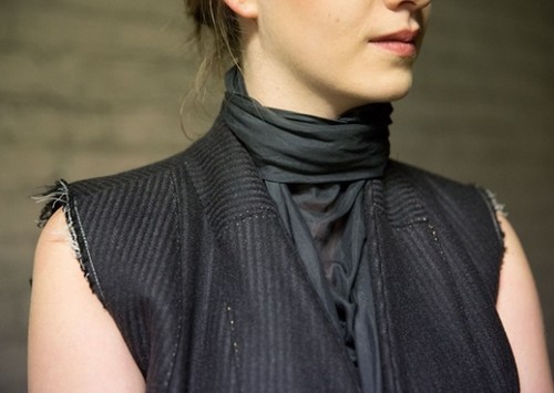 a piece of clothing without sleeves that is worn like a coat