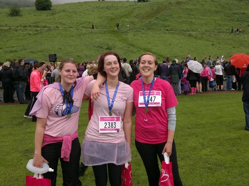 Three runners in pink, smiling.