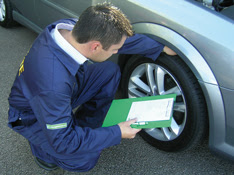 mechanic, Good Garage Scheme, WInter Check, checking tyre with clipboard