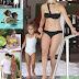 Jennifer Lopez displays her sculpted abs and toned legs in a bikini as she splashes around with her cute twins