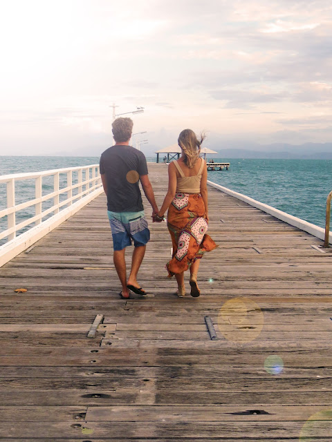 couple walking along pier hand in hand couple walking along pier hand in hand